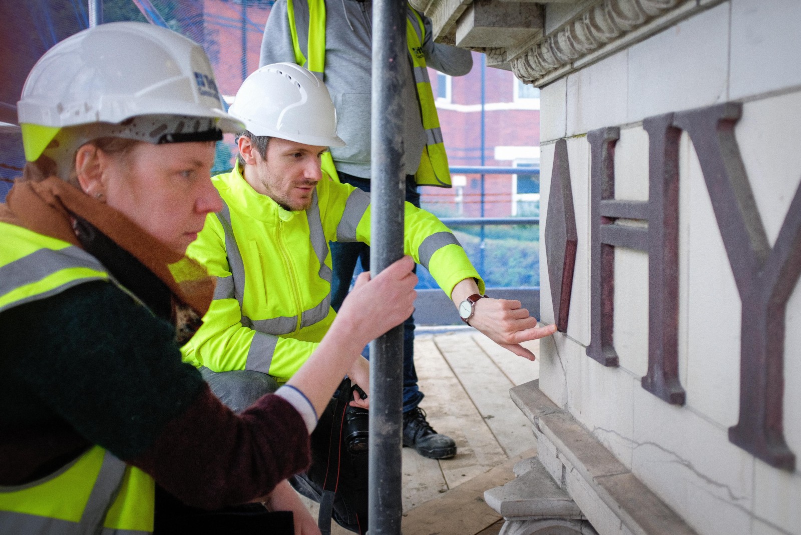 Lead architect, Mark, showing Wendy damage to the faience